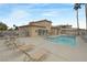 Community pool with lounge chairs, buildings, palm trees, and blue sky at 6701 Dorita Ave # 202, Las Vegas, NV 89108