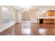 Bright living room showcasing wood floors, large windows, chandelier, and kitchen access at 689 Lucky Pine St, Henderson, NV 89002