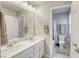 Bright bathroom with double sinks, large mirror, and a view of the commode and shower/tub at 7061 Tilligerry St, North Las Vegas, NV 89084