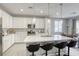 Bright kitchen featuring an island with barstool seating, stainless appliances and ample counter space at 7061 Tilligerry St, North Las Vegas, NV 89084
