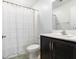 Bright bathroom showcasing a dark wood vanity, framed mirror, and a shower with a white curtain at 715 Pickled Pepper Pl, Henderson, NV 89011