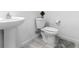 Bright bathroom with a pedestal sink, toilet, and tile floors provides a clean, modern look at 715 Pickled Pepper Pl, Henderson, NV 89011