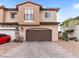 Two-story home featuring a two-car garage, a covered front porch and a neutral color scheme at 715 Pickled Pepper Pl, Henderson, NV 89011