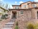 Charming two-story home featuring a stone facade, covered porch, and well-maintained desert landscaping at 715 Pickled Pepper Pl, Henderson, NV 89011
