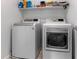 This laundry room features a modern, front-loading washer and dryer plus extra shelf storage at 715 Pickled Pepper Pl, Henderson, NV 89011