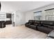 Bright living room with tile flooring, a comfortable leather sofa, and ample natural light through large windows at 715 Pickled Pepper Pl, Henderson, NV 89011