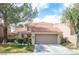 Charming two-story home featuring a tile roof, mature trees, well-manicured landscaping, and an attached two-car garage at 7566 Spanish Bay Dr, Las Vegas, NV 89113