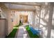 Inviting front entrance featuring artificial turf, a blue bench, and a walkway leading to a wood door at 7566 Spanish Bay Dr, Las Vegas, NV 89113