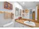 Cozy bathroom with a white sink, decorative mirror, and framed pictures hanging on the wall at 7889 Harbour Towne Ave, Las Vegas, NV 89113
