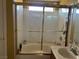 Bathroom showcasing a tub-shower combination with a white tiled surround and glass sliding doors at 8396 Yamhill St, Las Vegas, NV 89123