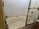 Close-up of a white soaking tub with a tile surround and a sliding glass door at 8396 Yamhill St, Las Vegas, NV 89123