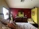 Bedroom featuring a vintage-inspired dresser, a patterned bedspread, and red accent wall at 8396 Yamhill St, Las Vegas, NV 89123