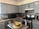 Well-equipped kitchen featuring grey cabinets, stainless steel appliances, and tiled countertops at 8396 Yamhill St, Las Vegas, NV 89123