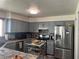 Functional kitchen features grey cabinetry, stainless steel appliances, and a mobile kitchen island at 8396 Yamhill St, Las Vegas, NV 89123