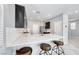 Modern kitchen with dark cabinetry, stainless steel appliances, quartz countertops, and three stools at 8502 Torozo Ave, Las Vegas, NV 89149