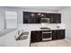 Modern kitchen with dark cabinetry, stainless steel appliances, and quartz countertops at 8502 Torozo Ave, Las Vegas, NV 89149