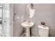 A quaint powder room featuring a pedestal sink, round mirror and neutral decor at 8502 Torozo Ave, Las Vegas, NV 89149