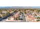 Elevated view of a community showcasing well-maintained homes, mature trees, and scenic mountain backdrop at 8901 Dio Guardi Dr, Las Vegas, NV 89117