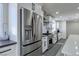 A stainless steel refrigerator complements the modern kitchen with white cabinets and gray countertops at 8901 Dio Guardi Dr, Las Vegas, NV 89117