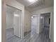 Hallway with multiple open doorways showing access to other rooms and closet space, and gray laminate flooring at 9662 Allison Ranch Ave, Las Vegas, NV 89148