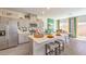 Open kitchen featuring stainless steel appliances, quartz countertops, an island with seating, and natural light at 9932 Ullom Dr # 5, Las Vegas, NV 89141