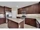 Open-concept kitchen featuring stainless steel appliances, granite countertops, wooden cabinets, and a kitchen island at , Las Vegas, NV 89131