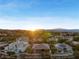 Expansive aerial view of luxury homes in a desert community with mountain views at sunset at 10 Greely Club Trl, Henderson, NV 89052