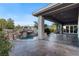 Backyard featuring a covered patio, a pool with rock waterfall, and lush landscaping at 10 Greely Club Trl, Henderson, NV 89052