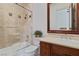 Bathroom showcasing tiled shower-tub, a toilet, and sink with wood cabinetry at 10 Greely Club Trl, Henderson, NV 89052