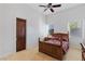 Bright bedroom with wood-framed bed and furniture, tiled floors, and natural light from the two windows at 10 Greely Club Trl, Henderson, NV 89052