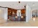 Kitchen with dark wood cabinetry, countertop seating, tiled backsplash, pendant lighting, and tile floors at 10 Greely Club Trl, Henderson, NV 89052