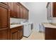This laundry room features built-in cabinets, a sink, a modern washer and dryer set, and neutral paint at 10 Greely Club Trl, Henderson, NV 89052