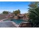 Swimming pool with rock features and a waterfall, surrounded by mature landscaping at 10 Greely Club Trl, Henderson, NV 89052