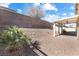 Desert landscaped backyard with covered patio and partial privacy fencing at 1009 Fishing St, Henderson, NV 89011