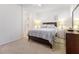 Carpeted bedroom with a queen-sized bed, neutral bedding, and an ensuite bathroom at 1009 Fishing St, Henderson, NV 89011