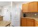 Bright kitchen with a large refrigerator, granite countertops and oak cabinets offering lots of storage at 1009 Fishing St, Henderson, NV 89011