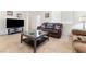 Comfortable living room with tile floors, a sleek entertainment center and a plush brown leather couch at 1009 Fishing St, Henderson, NV 89011