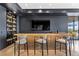 Well-stocked bar area featuring custom cabinetry, countertops with views of the outside patio at 11 Cloud Chaser Blvd, Henderson, NV 89012