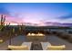 An outdoor fire pit with relaxing lounge chairs and cacti, overlooking a beautiful city view at 11 Cloud Chaser Blvd, Henderson, NV 89012