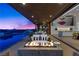 Outdoor patio area featuring a modern fireplace, comfortable seating, an infinity pool, and breathtaking mountain views at 11 Cloud Chaser Blvd, Henderson, NV 89012