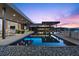An infinity pool surrounded by desert landscaping with an outdoor dining area and comfortable lounge chairs at 11 Cloud Chaser Blvd, Henderson, NV 89012
