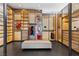Spacious walk-in closet features custom wood cabinetry, glass doors, and central ottoman seating at 11 Cloud Chaser Blvd, Henderson, NV 89012