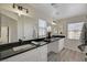 Bathroom featuring dual sinks, black countertops, and large mirror at 11159 African Sunset St, Henderson, NV 89052