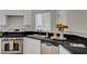 Stylish kitchen with stainless steel appliances, black countertops, and bright white cabinets at 11159 African Sunset St, Henderson, NV 89052