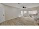 Open-concept living room with modern light fixtures, wood flooring, and sliding glass doors leading to the backyard at 11159 African Sunset St, Henderson, NV 89052