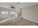 Bright living room with wood flooring, a ceiling fan, and sliding glass doors leading to the backyard at 11159 African Sunset St, Henderson, NV 89052