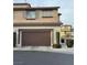 Exterior view of a two-story home with a brown garage door and landscaped front yard and neutral color scheme at 11489 Belmont Lake Dr # 106, Las Vegas, NV 89135