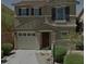 Two-story home featuring a garage, front yard with minimal landscaping, and neutral color palette at 12045 Yarrow Ridge Ct, Las Vegas, NV 89183