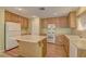 Functional kitchen featuring wood cabinets, a central island, and laminate floors, and ample counter space at 12045 Yarrow Ridge Ct, Las Vegas, NV 89183