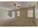 Spacious carpeted living room featuring a ceiling fan, backyard access, and neutral paint at 12045 Yarrow Ridge Ct, Las Vegas, NV 89183